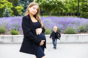 Pregnant mother and her son walking and funny spending time together photo