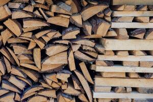 A stack of chopped firewood and logs arranged in neat rows for drying and storage. photo