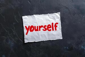 Self-esteem concept on a piece of paper with the word yourself written on it photo