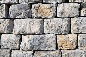 A stone wall made of large blocks of stone photo