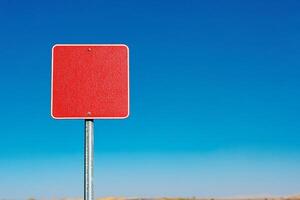 A red traffic sign on a pole in the middle of a desert photo