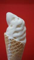 A waffle cone with whipped cream on a red background photo