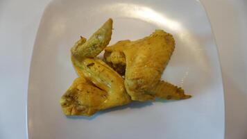 A white plate with chicken wings on it photo