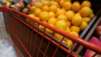 A red metal cart with oranges and lemons in it photo