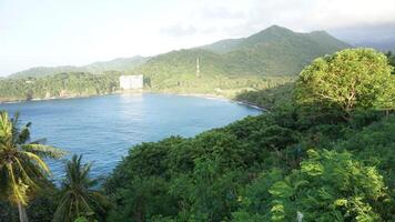 A view of the ocean and mountains from a hill photo