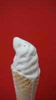 Ice cream cone with white icing on a red background photo