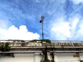 A cell phone tower on top of a concrete wall photo