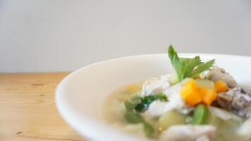 A bowl of soup with vegetables and meat in it photo