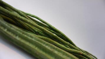 A bunch of green beans on a white surface photo