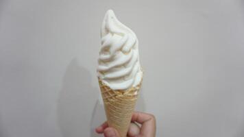 A hand holding a cone of ice cream photo