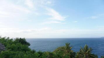 A man standing on a hill overlooking the ocean photo
