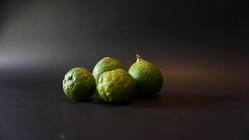 Three green limes on a black background photo
