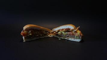 A half eaten sandwich on a black surface photo