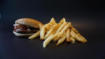 A hamburger and french fries on a black surface photo