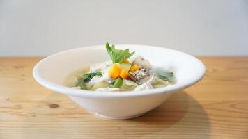A bowl of soup with vegetables and meat in it photo