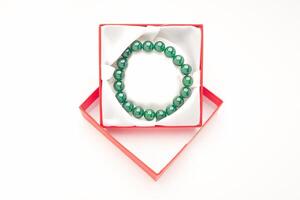 Jade bangle or bracelet in a red box on a white background. Close-up. photo