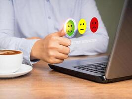 Choosing a green happy mood icon rating review in the survey of customer satisfaction on a virtual screen photo