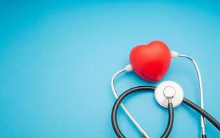 Top view of a stethoscope and a red heart shape on a blue background photo