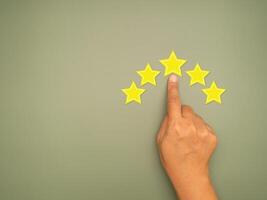 Top view of rating for Satisfaction is present by the hand of Client pressing Five Star photo
