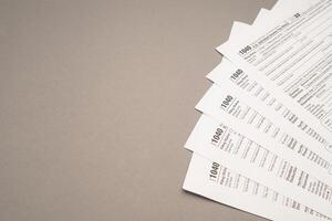 TAX form on a gray background. Assistance with filing tax forms and calculations photo