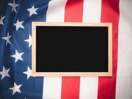 Top view of a mini chalkboard over the American flag background. photo