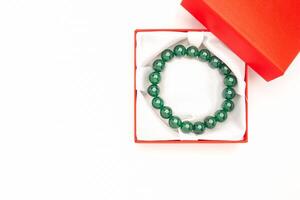 Jade bangle or bracelet in a red box on a white background. Top view. photo