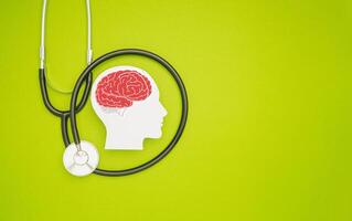 A brain shape symbol and a stethoscope on a green background photo
