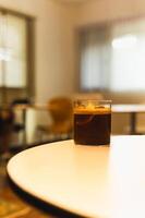 Iced coffee with slice of orange on table in cafe. photo