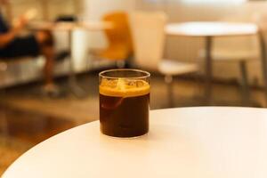 Iced coffee with slice of orange on a table in cafe. photo
