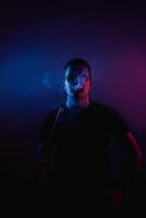 Man enjoys a moment of tranquility while smoking in neon-lit hookah bar atmosphere photo