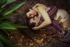 Couple enjoying a cozy moment on a soft carpet with warm lights and a peaceful atmosphere photo