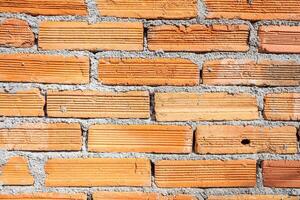 Weathered orange color brick wall for brickwork background design photo