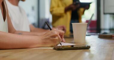 A person writing on a piece of paper while sitting at a table video