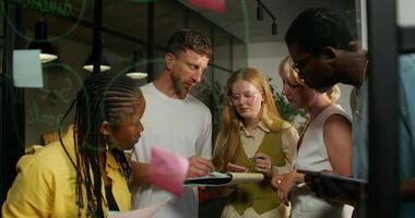 A group of people standing around a table with sticky notes video