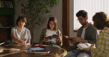 A group of people sitting around a table reading books video