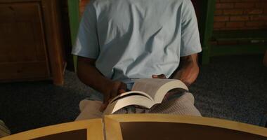 A man sitting at a table reading a book video