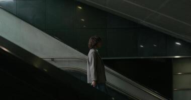A man walking down an escalator in a building video