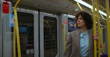 A woman in a suit and tie standing on a subway train video