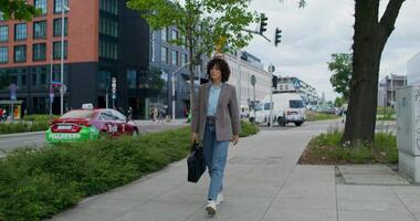 A woman walking down a sidewalk with a bag video