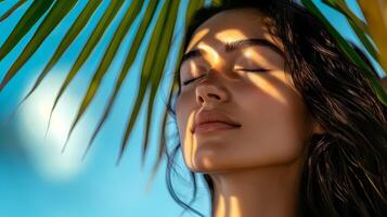 Beautiful model enjoying tropical vacation under palm tree photo