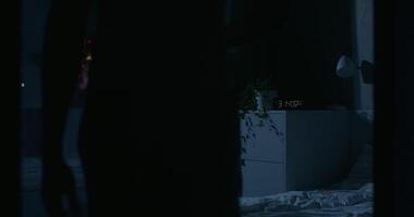 A person standing in front of a bed at night video