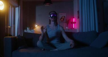 A woman wearing a virtual reality headset sits on a couch video
