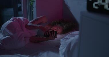 A woman sleeping in bed with a phone video