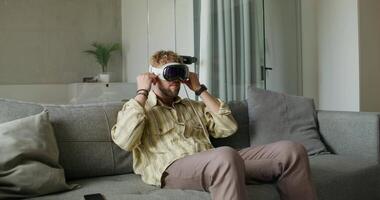 A man sitting on a couch with a virtual reality headset video