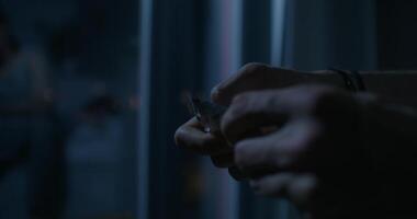 A person holding a cigarette in front of a window video