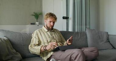 A man sitting on a couch with a tablet computer video