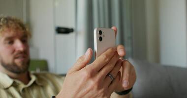 A man holding a cell phone while looking at it video