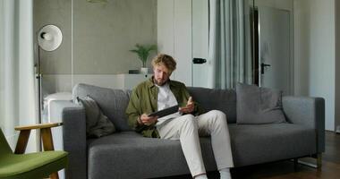 A man sitting on a couch with a tablet computer video