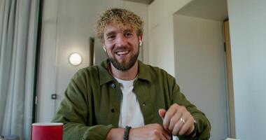 A man with a beard smiles while sitting at a table video