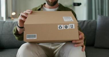 A man is holding a cardboard box with a label on it video